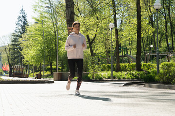 Fototapeta premium Brunette runner woman runs in the park jogging, concept of training exercise