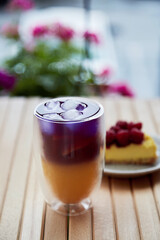 Natural summer cold refreshing purple and yellow cocktail. Anchan blue tea - antioxidants and detox water. Drink with condensate at the terrace and raspberry cake outside