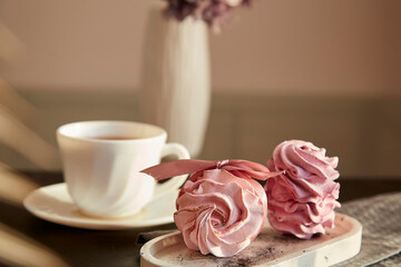 Aesthetic tender dessert - marshmallows with currant and cup of black tea. Blurred foreground. Autumn cozy breakfast. Healthy sweets, sugar and gluten free natural food.