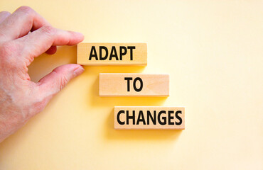 Adapt to changes symbol. Concept words Adapt to changes on wooden blocks. Businessman hand....