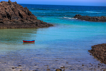 Fototapeta na wymiar beach and rocks and and a boat