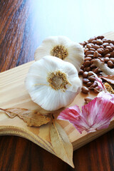 Garlic bulbs. Closeup of garlic bulb with bay leaves and carioca beans on the cutting board.