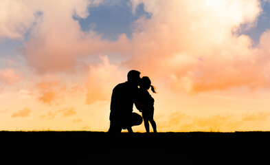 Fototapeta na wymiar Parent and child silhouette. Dad and his little girl giving him a kiss on the cheek. 