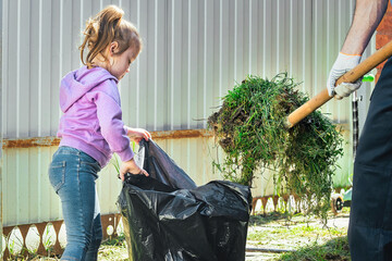 adults and children do household chores together, clean and tidy. dad and little girl clean leaves...