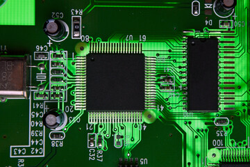 Close-up of electronic circuit board PCB with components: microchip, processor, integrated circuits, capacitors, resistances and electronic connections are noted. macro photography.