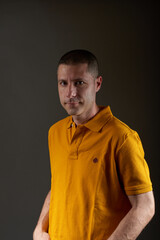 Obraz premium Young man in yellow t-shirt posing in a studio