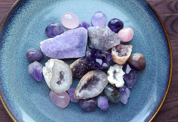 Beautiful semi-precious stones of different colors on a ceramic blue plate. Druses, crystals and...