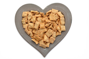 whole grain flakes cinnamon pads in a heart-shaped frame on a white background