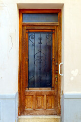 Old, wooden door. Retro styled door in light brown color. Door in details. Menorca, Spain