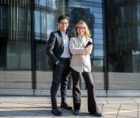 Two young confident managers a woman and a man in business suits go to work in a new office