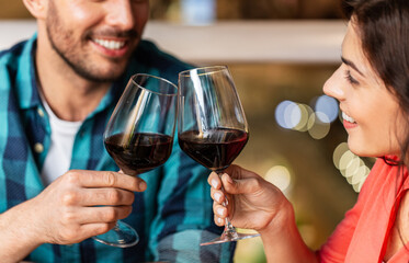 leisure, drinks and people concept - close up of happy couple drinking red wine at restaurant