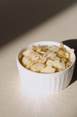 almonds in a light bowl on a table on a light background