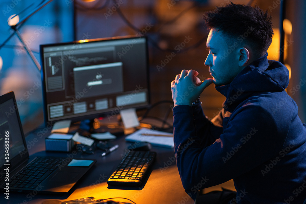Poster cybercrime, hacking and technology concept - male hacker in dark room using computer virus program f