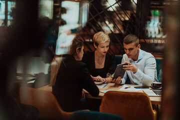 Happy businesspeople smiling cheerfully during a meeting in a coffee shop. Group of successful business professionals working as a team in a multicultural workplace.