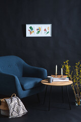 interior and home decor concept - close up of blue chair, coffee table and blanket in basket in dark room