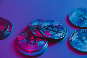 Bitcoin coins under neon light. The currency of the future.