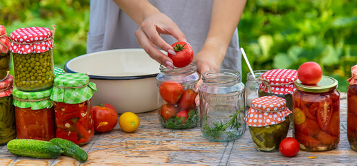 A woman preserves vegetables in jars. Selective focus.