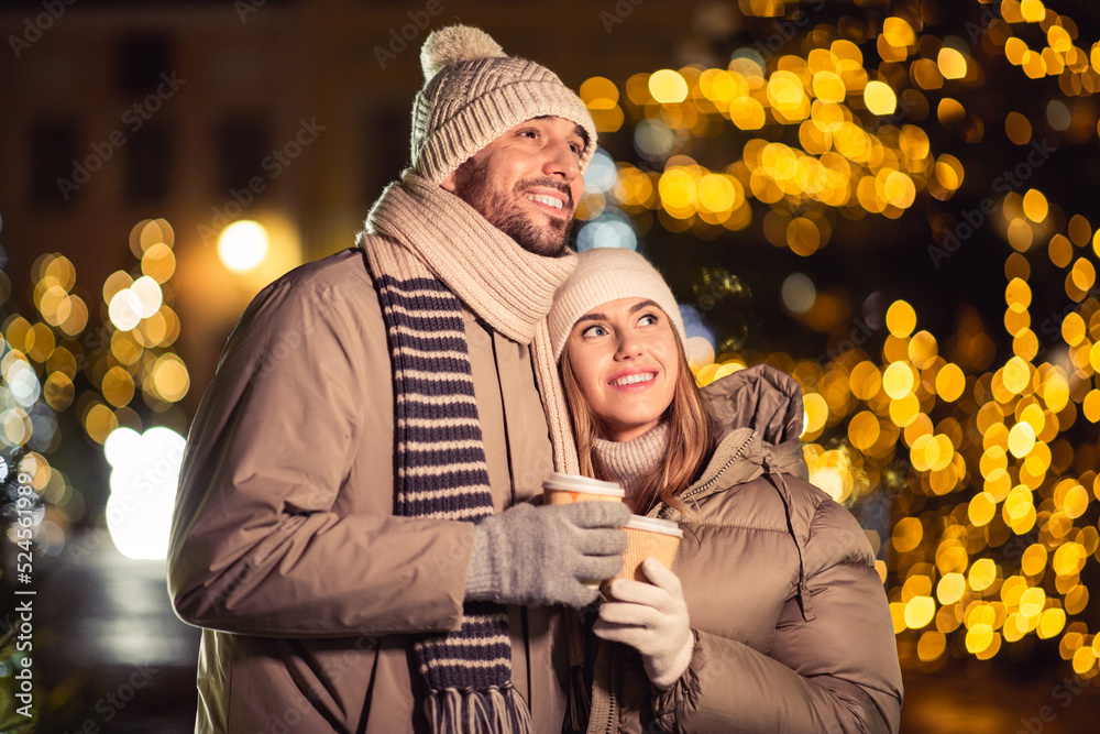 Canvas Prints winter holidays, hot drinks and people concept - happy young couple with takeaway coffee cups in chr