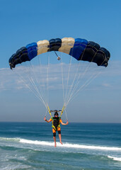 Skydiver flying over the beach