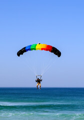 Skydiver flying over the beach