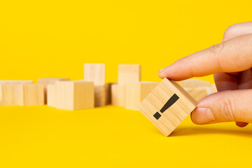 wooden block in exclamation mark on yellow background