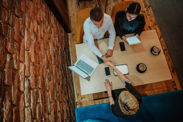 Top view of photo businesspeople smiling cheerfully during a meeting in a coffee shop. Group of successful business professionals working as a team in a multicultural workplace.