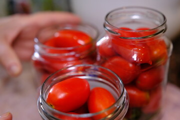 Fototapeta na wymiar Homemade pickled tomatoes in glass jars Fermented tomatoes in transparent glass. Homemade canned tomatoes.