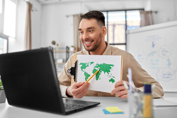 distance education, school and remote job concept - happy smiling male geography teacher with world map and laptop computer having online geography class at home office