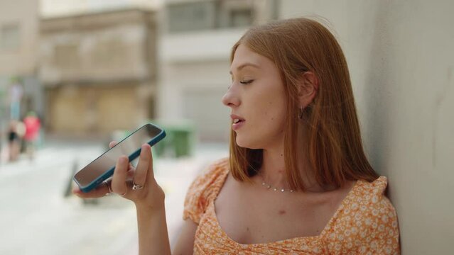 Young redhead woman smiling confident talking on the smartphone at street