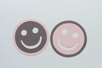 pink and gray paper smileys on blank paper