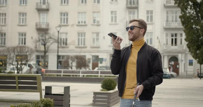 man walking in nature on the side walk holding a stick he is blinded needed directions