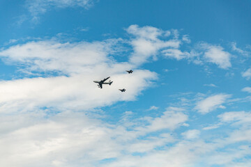 aviation, aircraft and transport concept - group of military airplanes flying in blue sky