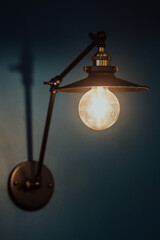 Old light bulb on a modern blue wall. Selective focus 