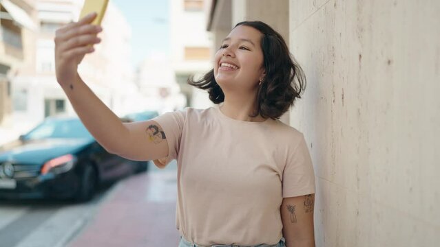 Young woman smiling confident making selfie by the smartphone at street