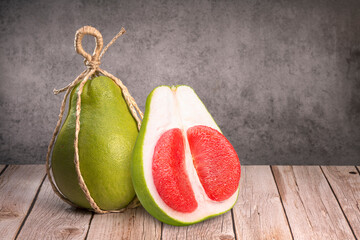 Red Pomelo citrus fruit on wooden background, Whole pomelo with slice on wooden background.