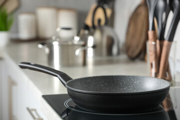 Frying pan and cooking utensils in kitchen, space for text