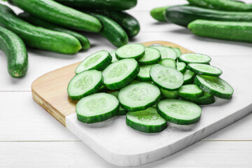 Fresh ripe cucumbers on white wooden table