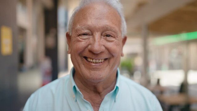 Senior grey-haired man smiling confident standing at street