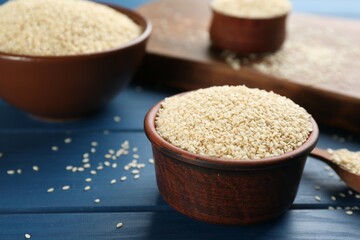 Sesame seeds in bowls on blue wooden table