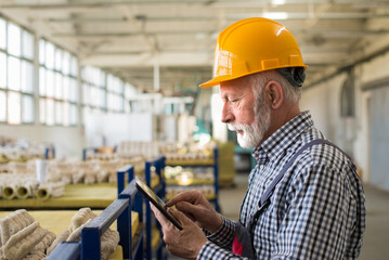 Senior man blue collar worker working in the factory