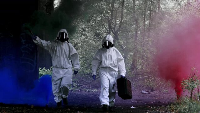 Polluted, post nuclear area with abandoned warehouse and colorful smoke. Scientist in safety uniforms picking samples carrying signal flares