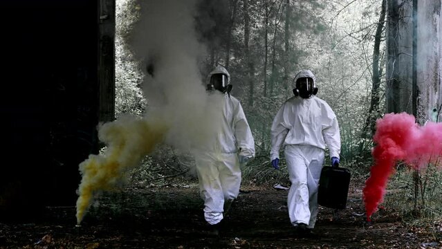 Polluted, post nuclear area with abandoned warehouse and colorful smoke. Scientist in safety uniforms picking samples carrying signal flares