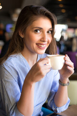 Young woman drinking coffee in the coffee shop