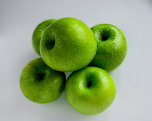 five green appels on white background