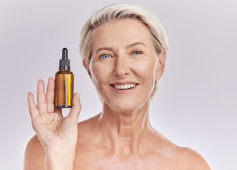 Skincare, beauty or makeup product in the hand of a senior woman holding face serum or cosmetic oil in studio on a purple background. Portrait of a female marketing, advertising or endorsing wellness