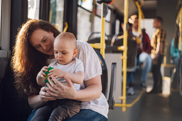 Mother and her child riding in a bus during a day.