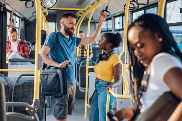 Multiracial friends talking while riding a bus in the city