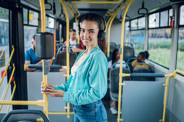 Fototapeta na wymiar Woman paying a bus ticket via smartphone during a ride