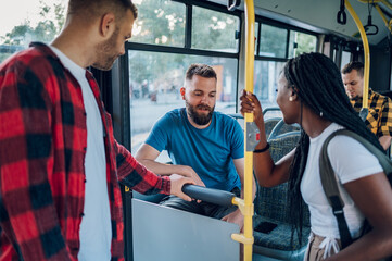 Multiracial group of friends talking while riding in a bus