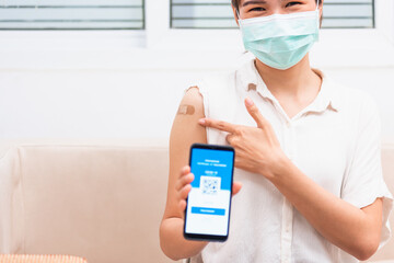 woman pointing to adhesive plaster on arm her vaccinated and showing app smartphone mobile digital screen vaccinated
